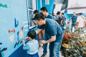 Bersama murid-murid dan sejumlah wartawan nasional, Rudy Chen menyelesaikan mural di bagian dinding depan PAUD Terpadu Perwari Trisula