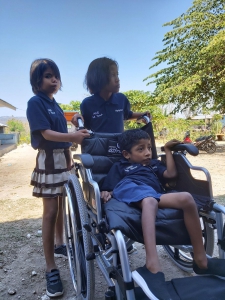 Darwin (duduk) adalah satu dari empat anak Desa Watu Kawula yang menerima bantuan kursi roda dari Asuransi Astra.