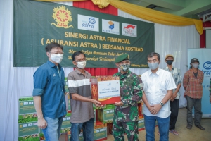 Aster Kakostrad, Heri Susanto (kedua kanan) turut membantu memberikan paket sembako dari Asuransi Astra kepada perwakilan warga yang hadir.
